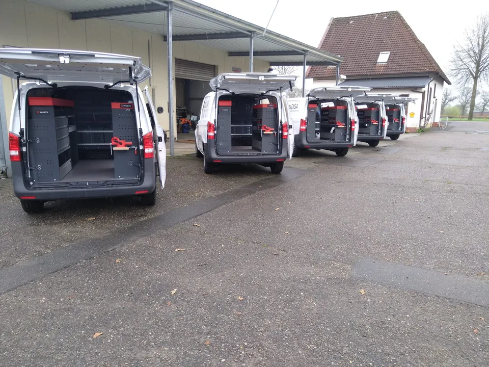 Mehrere ausgestattete Transporter vor der Werkstatt