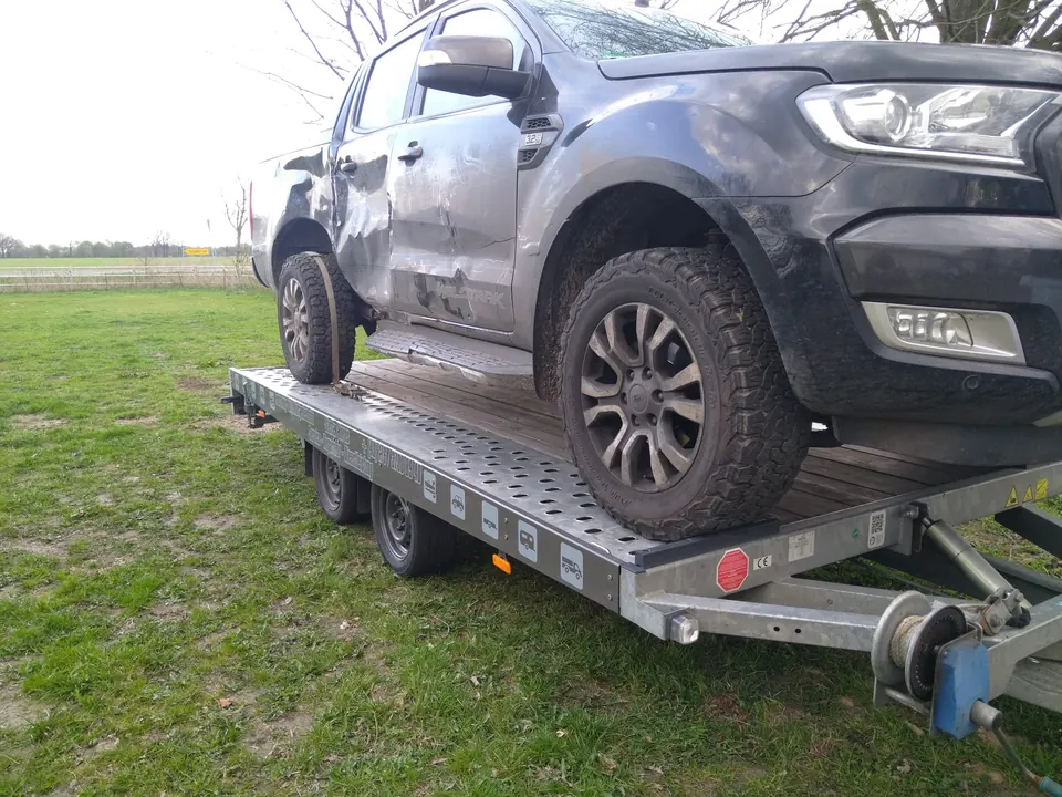Beschädigtes Fahrzeug auf einem Transportanhänger