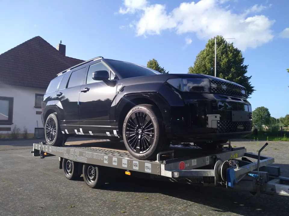 Schwarzer SUV auf einem Transportanhänger