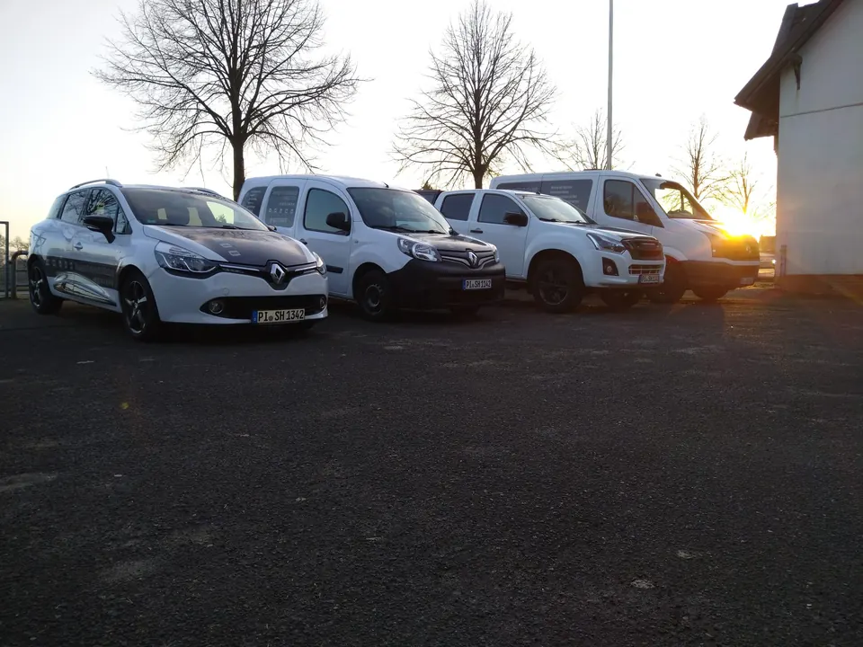 Mehrere Fahrzeuge bei Sonnenuntergang am Werkstattstandort